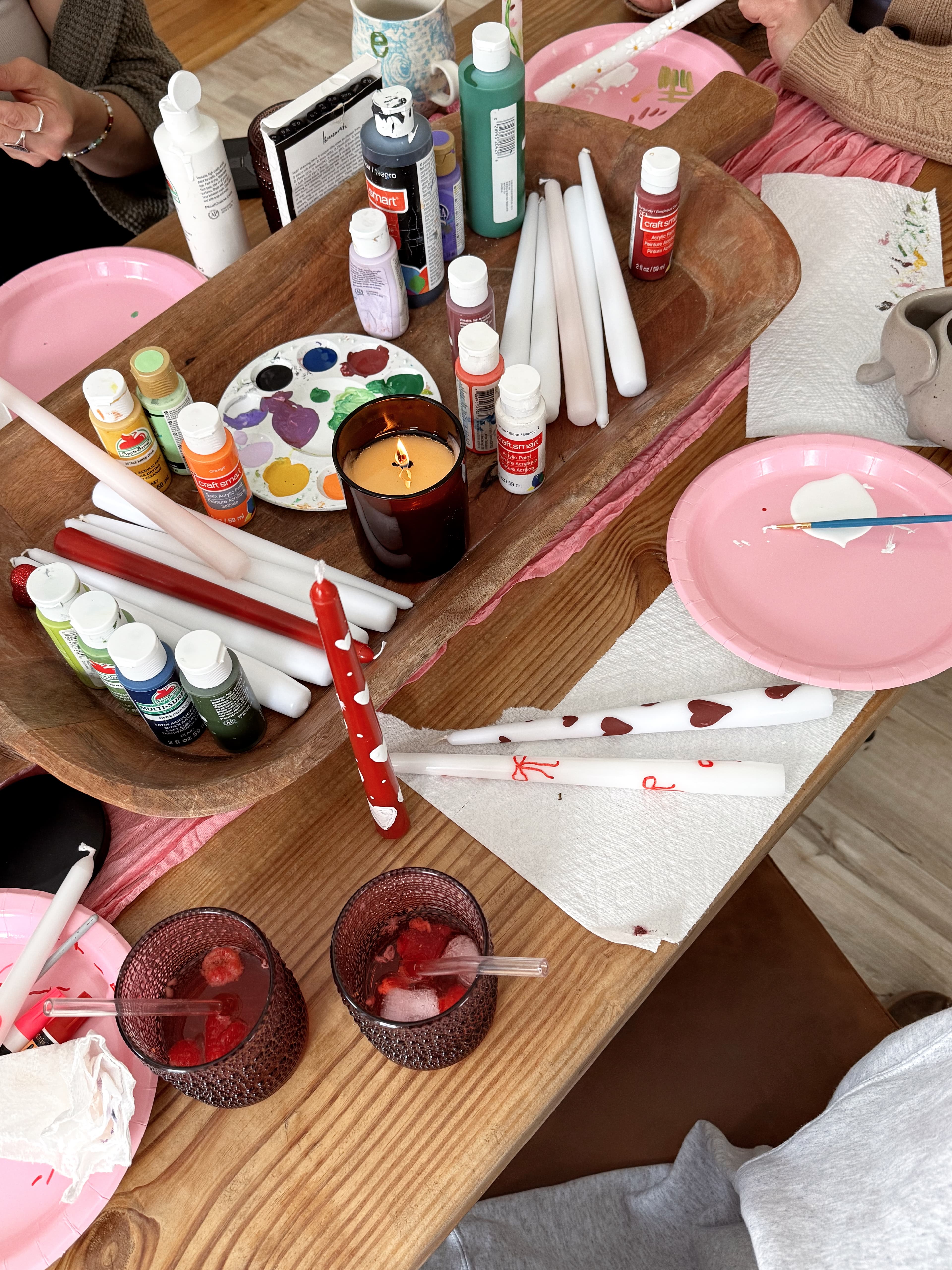 Candle-painting supplies and drinks on a table