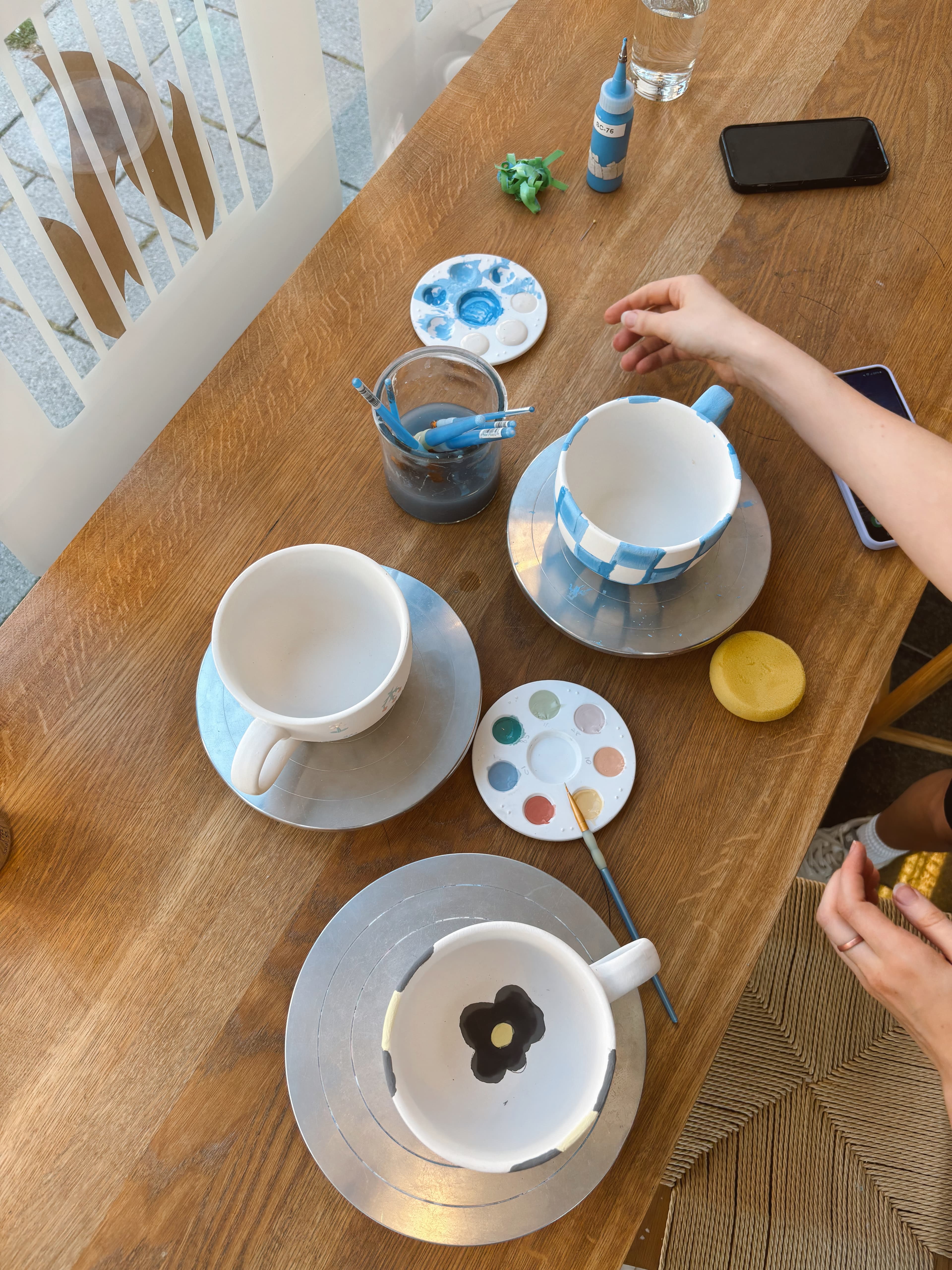 Couple painting mugs together at a table